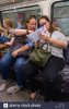 two-women-looking-at-tube-map-while-riding-a-london-underground-train-city-of-westminster-lond...jpg